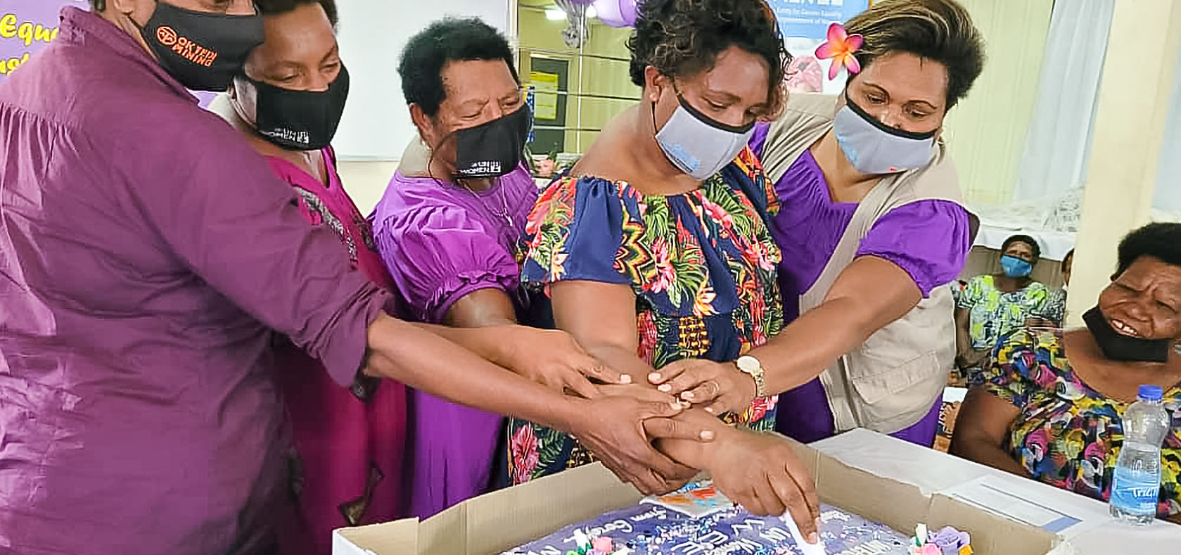 Goroka market vendors cut a cake as part of the commemoration to mark the International Women’s Day 2022. Photo: UN Women/Aidah Nanyonjo