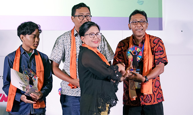 Prof. Dr. Vennetia Danes, Deputy Minister for Protection of Women’s Rights presented the winning trophy to first prize winner, Bagus Aji Mandiri. Photo: UN Women/Aloke Pictures