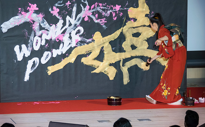Yuuna Okanishi creates a live calligraphy performance with the words 'women' and 'power', to piano accompaniment by Takashi Matsunaga. Photo: UN Women/STORY CO., LTD https://flic.kr/p/GLoHYj