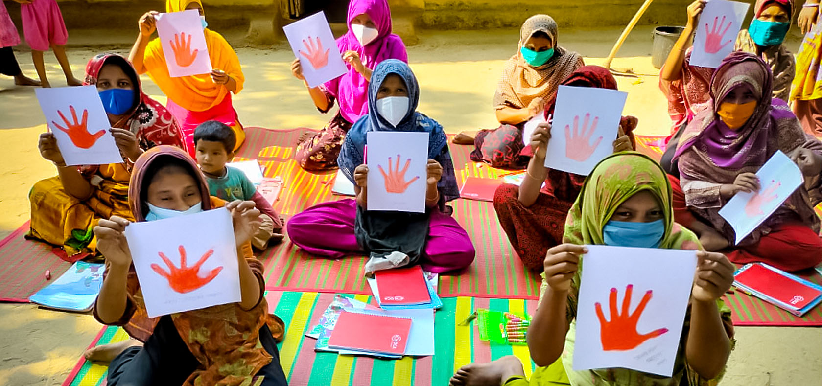 Women from a Bangladeshi community around a Rohingya refugee camp in Cox’s Bazar, Bangladesh, show their paintings signaling, “Stop violence against women and girls”. The event was held at a UN Women facility at Ukhia on 25 November 2021 as part of the United Nations 16 Days of Activism against Gender-based Violence. Photo courtesy of DanChurchAid