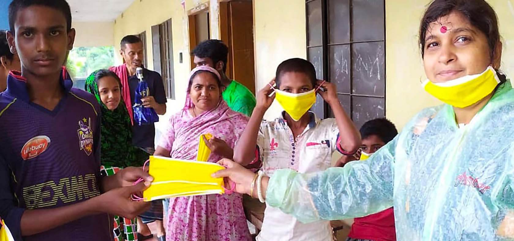 Shampa Goswami (pictured right) and the Prerona team distribute food packets and masks at cyclone shelters in the wake of cyclone Amphan. Photo: Prerona
