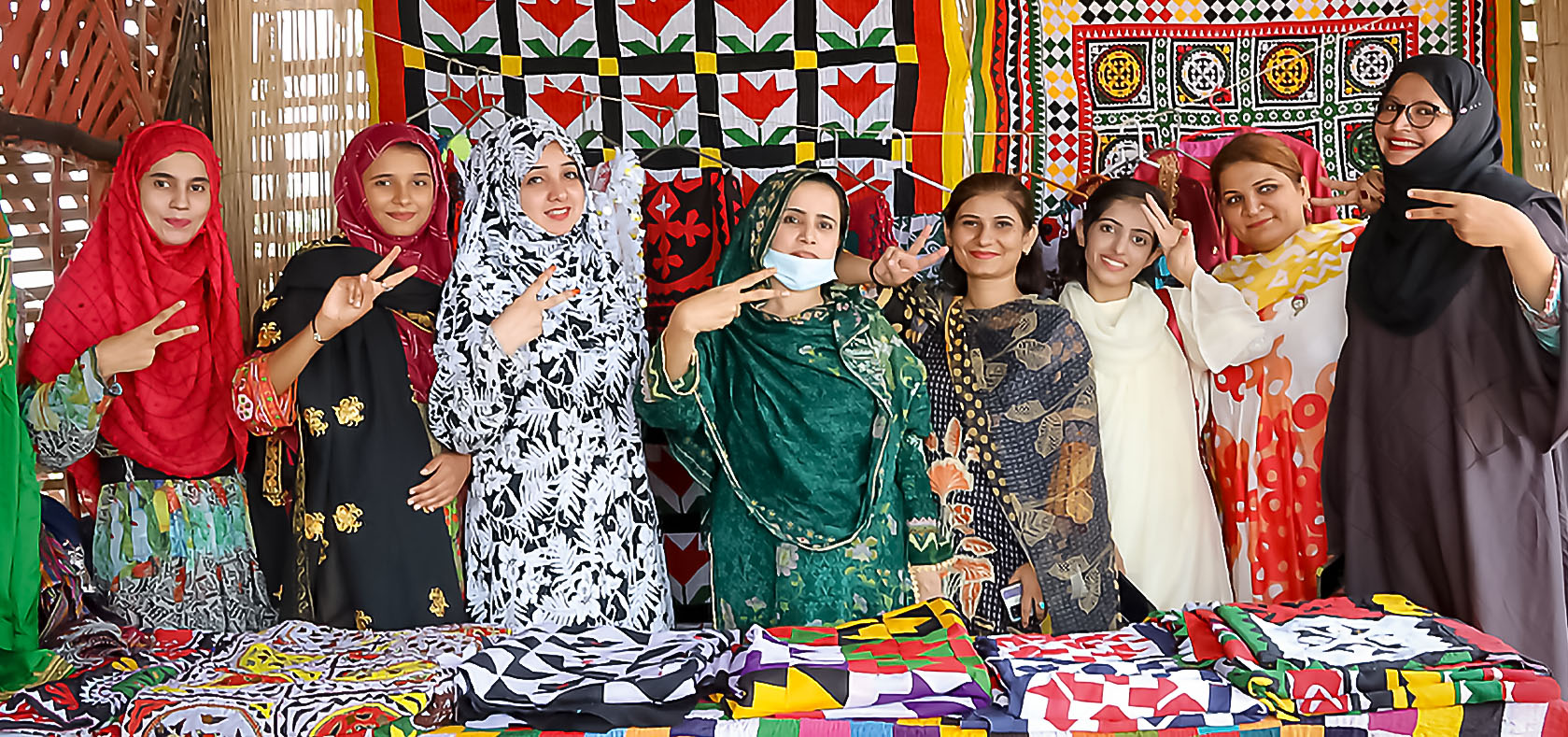 Around ten women, standing and selling their handicrafts. Photo: UN Women/Anam Abbas