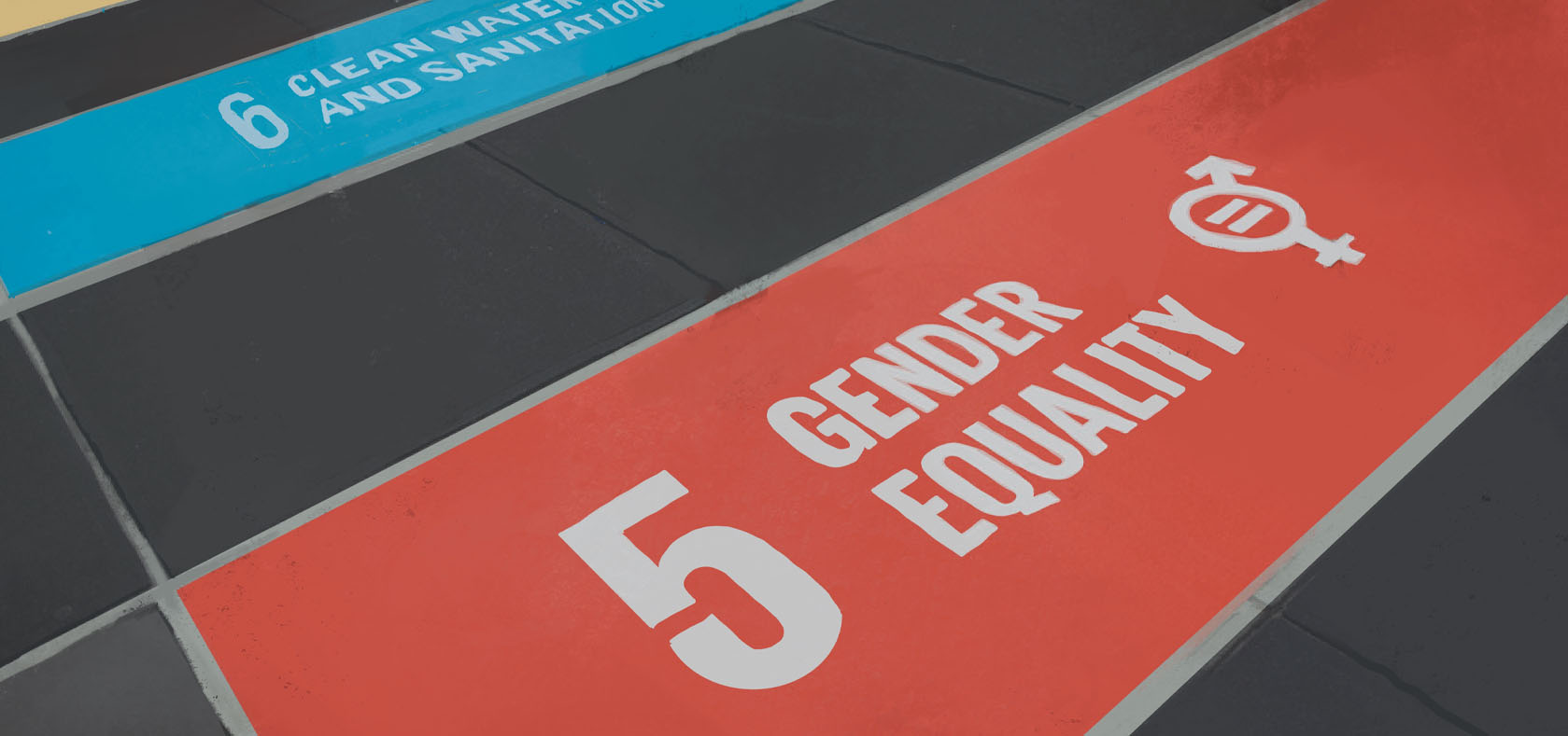 SDG 5 banner, white text on red background; had been laid on the floor. There is an SDG 6 banner in light blue partially shown on the top