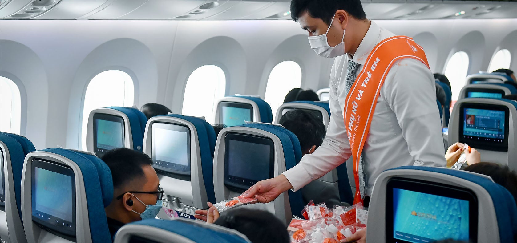 Crew members distributed orange flower pins to the passengers. Photo: Courtesy of Vietnam Airlines