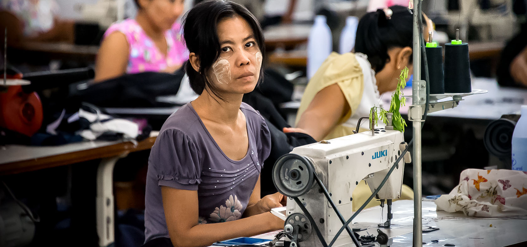 Myanmar migrant workers sew clothes in a factory in Thailand's western province of Mae Sot.  Photo: UN Women/Piyavit Thongsa-Ard