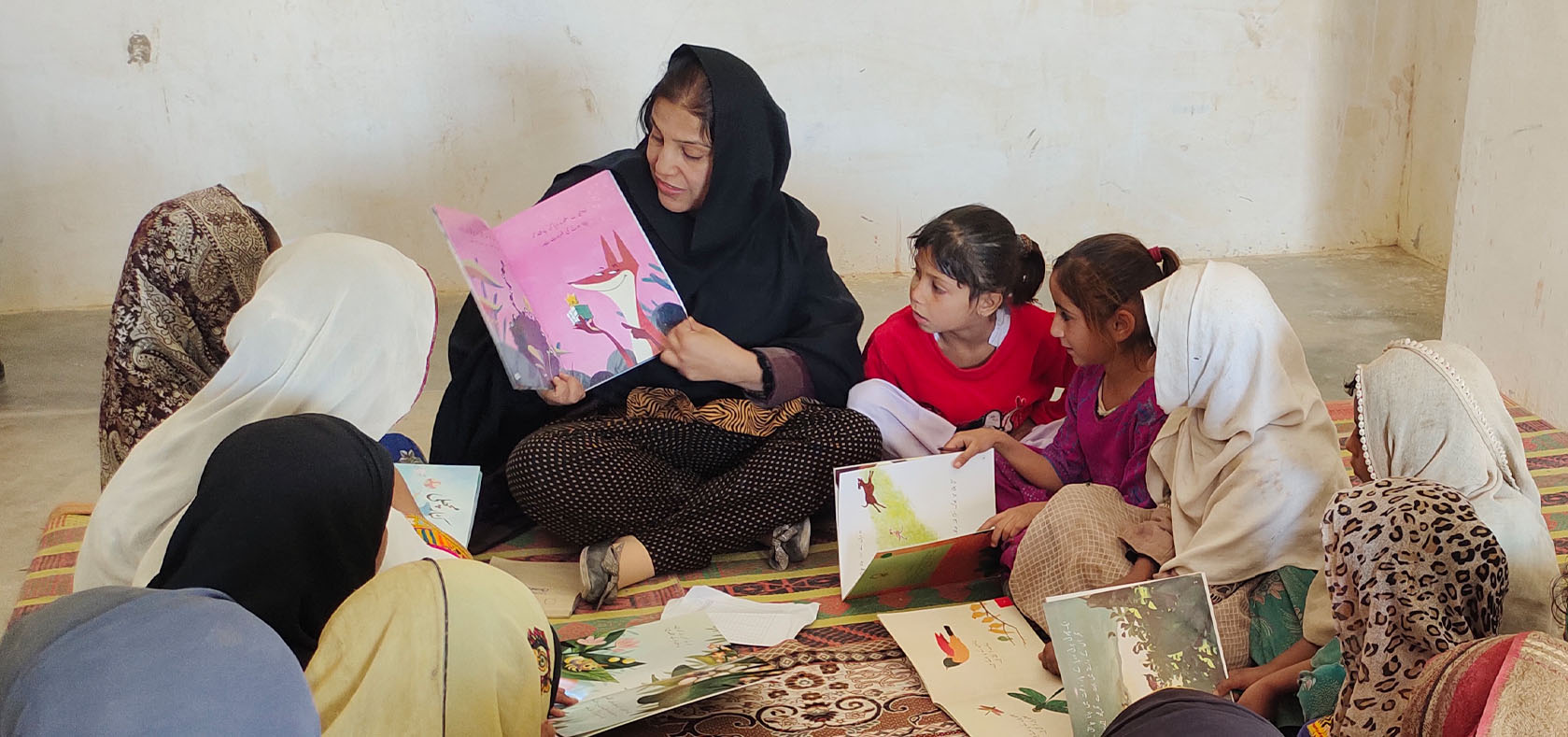 Sumera Mehboob reads a short story to girls supported by their organization. Photo: Courtesy of Sumera Mehboob