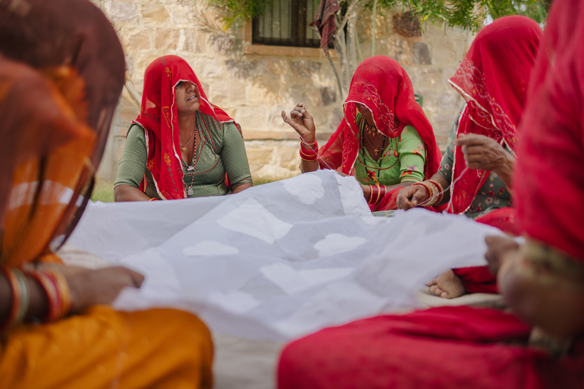 Indigenous women artisans, from the self-help group Gramin Vikas Evam Chetna Sansthan, discuss the design for their upcoming embroidery project in Barmer, Rajasthan.