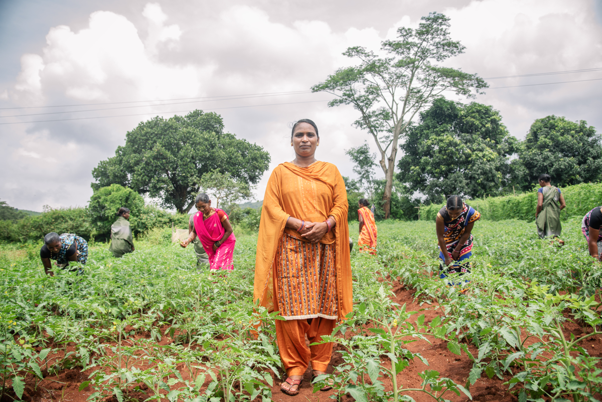 Laki Jani stands in a farm with other women, who work alongside her to raise awareness in their respective communities about sustainable farming practices. When she started working in the Panchayat, a locally governed village council, in 2018, she worked in 13 villages. Now she works with two Panchayats, approximately 23 villages, and 6,000 women farmers. 
