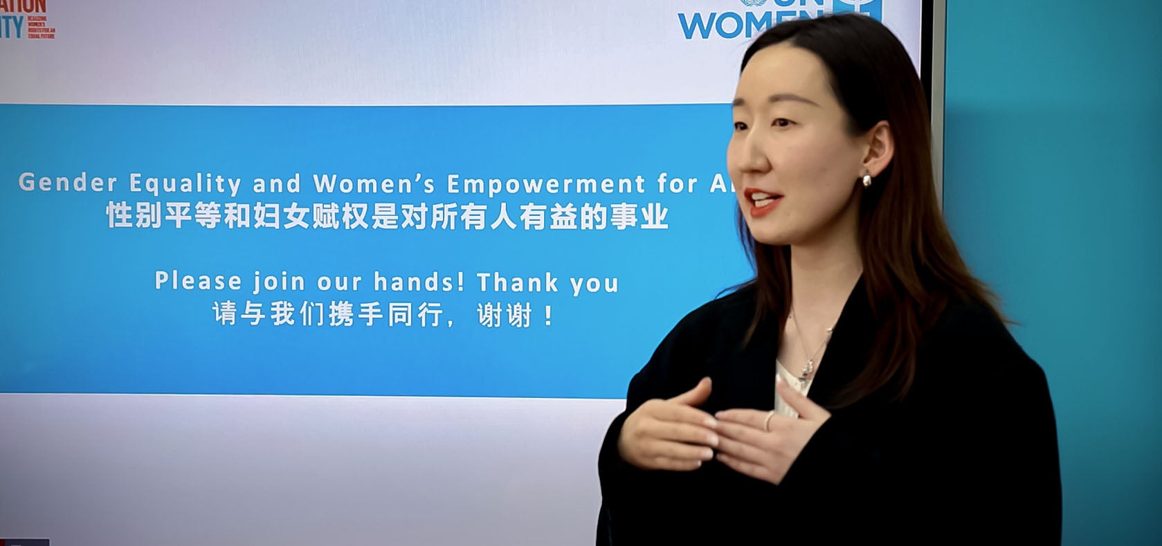 Xiaerbati Daositeke, a Chinese woman is standing in front of a big LCD screen (around 85 inches) while providing her lecture on Gender Equality and Women empowerment.