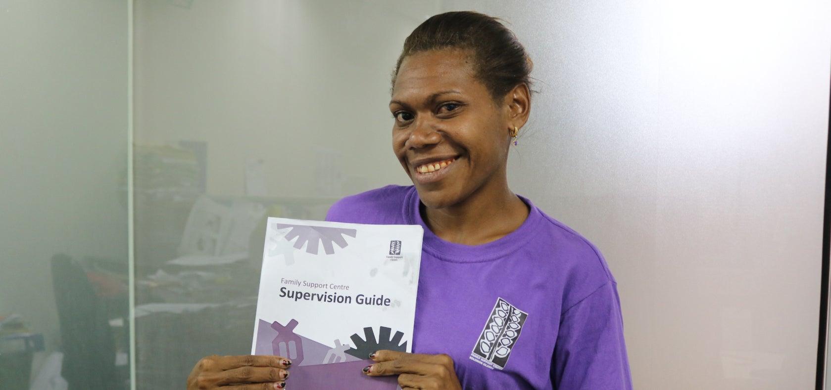 Sophie Rolyn, a team leader at the Neo Provincial Committee of the Family Support Center (FSC), with the Counselling Supervision Guide developed for FSC by UN Women. 