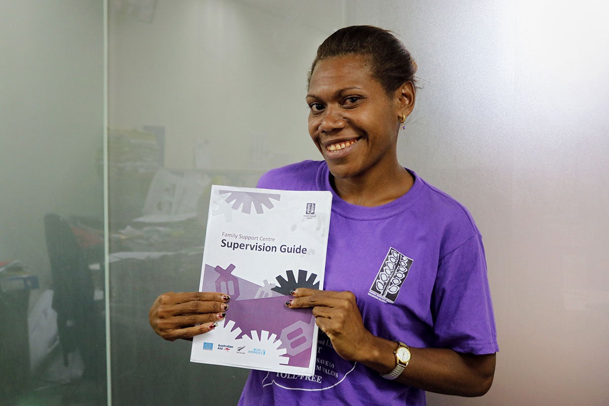 Sophie Rolyn, a team leader at the Neo Provincial Committee of the Family Support Center (FSC), with the Counselling Supervision Guide developed for FSC by UN Women. 