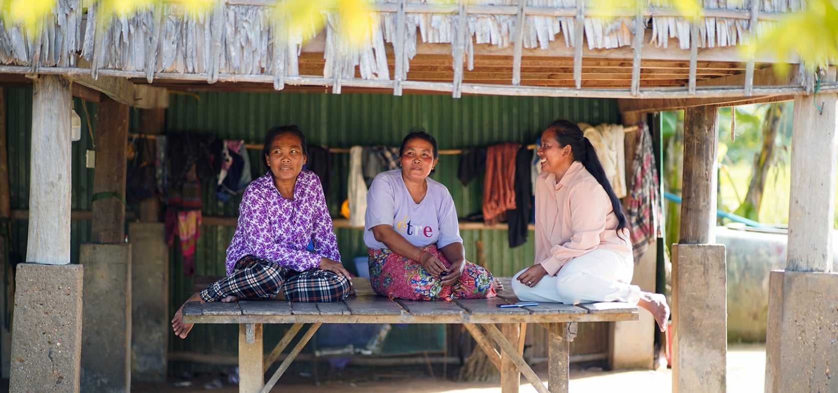 Sreymom sits with other women in her community. Through her work as a Peer Leader and now as a Kindergarten teacher, she has become a respected figure in her community, empowering other women migrant workers with knowledge and support. 