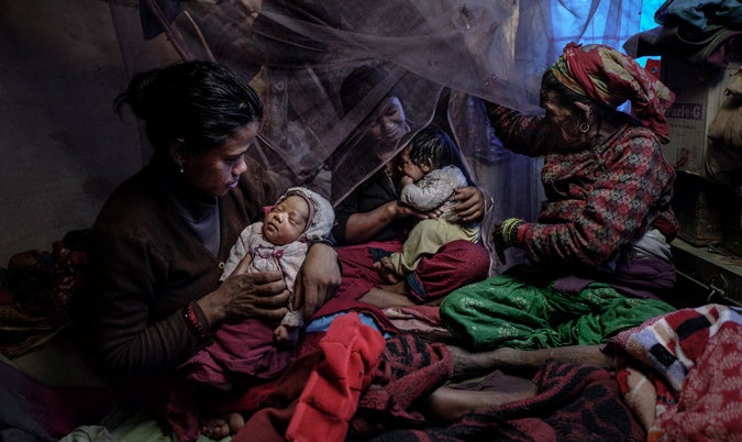 Earthquake victims. Mother and new born baby, together with their family of 12 share this desperate tiny shelter, their home and all belongings destroyed by the force of the quake. Usually the return home of a new baby would be cause for great celebration in the family, however, Shanta and new baby Rehan have little to celebrate.  Photo: UN Women/Piyavit Thongsa-Ard