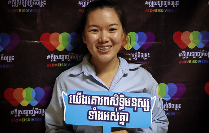 Srong Seavmey, 21, holding up the message, “We all respect human rights,” at the LOVEISDIVERSITY media platform launch at Pannasastra University of Cambodia on 8 June. Photo: UN Women/Sreynich Leng