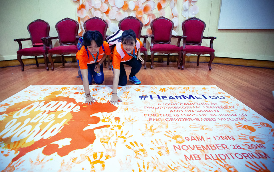 Students print their palms in orange at a 28 November ceremony at Philippine Normal University to express their commitment to speak out against sexual harassment. Photo: UN Women/Norman Gorecho