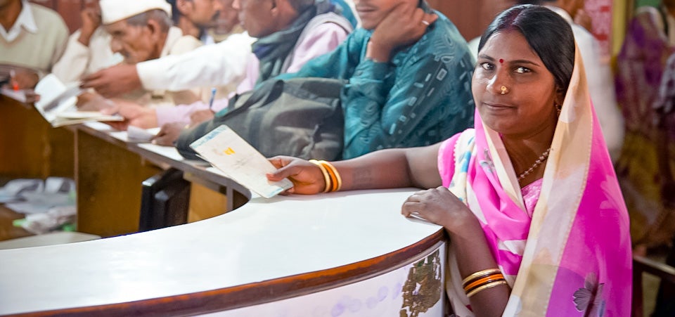 Haribai fought all odds to become a worksite supervisor under the world’s largest pay-for-work programme, MGNREGA. Here she collects her earnings at the local bank in the Lalitpur district of Uttar Pradesh. As part of a project supported by UN Women’s Fund for Gender Equality and Gender at Work, Haribai and 9000 other Dalit women opened bank accounts to control the money they earn. All-women worksites, stronger collectives and trained women supervisors helped 30,000 Dalit women in Uttar Pradesh and Andhra Pradesh to learn about and benefit from MGNREGA.   Photo: UN Women/Gaganjit Singh