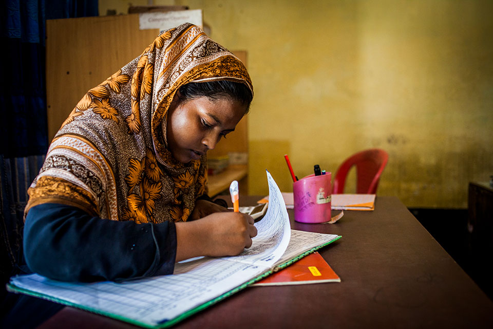 A worker checks in her daily attendance sheet at Ghop Nawapara Road in Jessore. Photo: UN Women/Fahad Kaizer