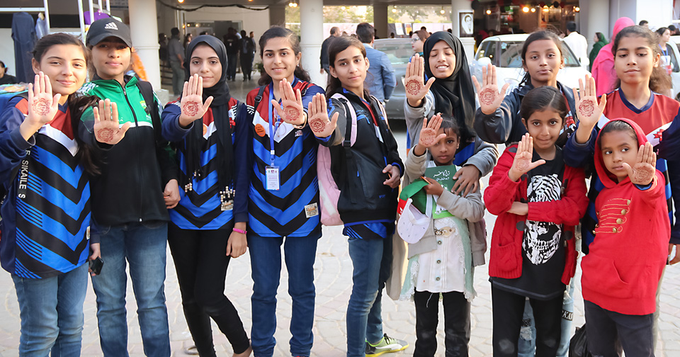 Young students from Karachi send out the message with their dyed palms: stop dowry mongering. Photo: UN Women/Habib Asgher