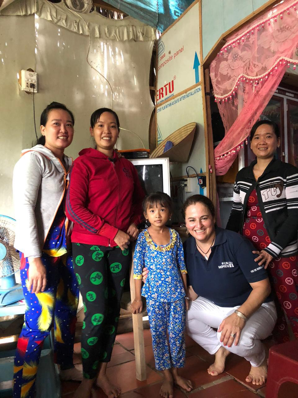 UN Women Representative in Viet Nam Elisa Fernandez Saenz (front right) visits the home of grant recipient Nguyen Qunyh Chi (second from left) in Tran Van Thoi district on 14 October and hugs her daughter, Joining them are Nguyen’s sisters. Photo: Tran Thi Thuy Anh