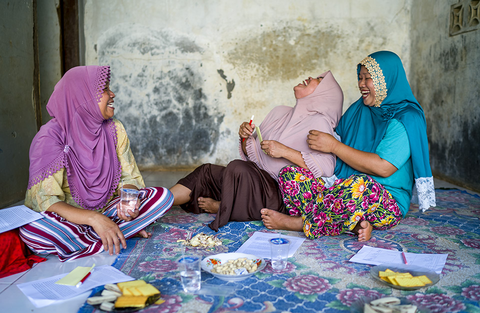 In the photo, three Indonesia women are working and laughing at the same time