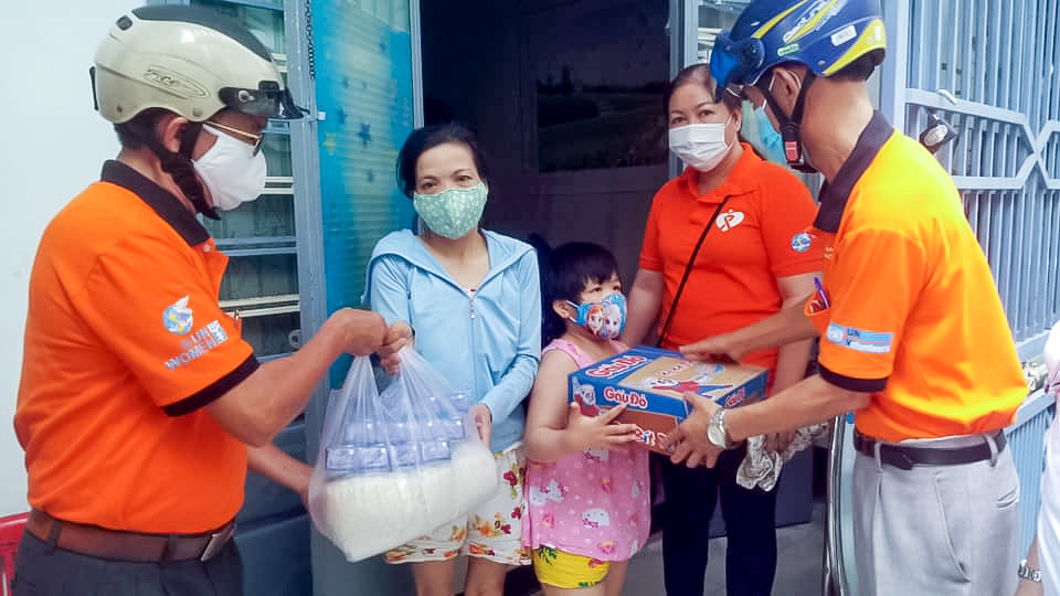 Members of Da Nang male advocates clubs (in orange T-shirts) distribute rice, milk and instant noodles to vulnerable families. Photo courtesy of Da Nang Women’s Union