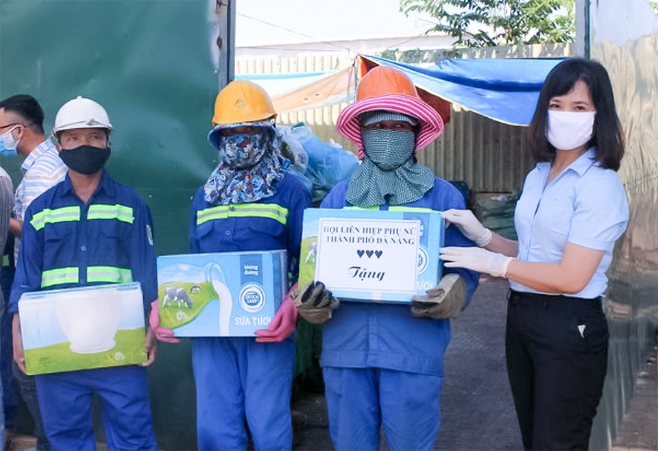 Hoang Thi Huong (right) gives milk and cash to people affected by the COVID-19 epidemic in Da Nang. Photo courtesy of Da Nang Women’s Union