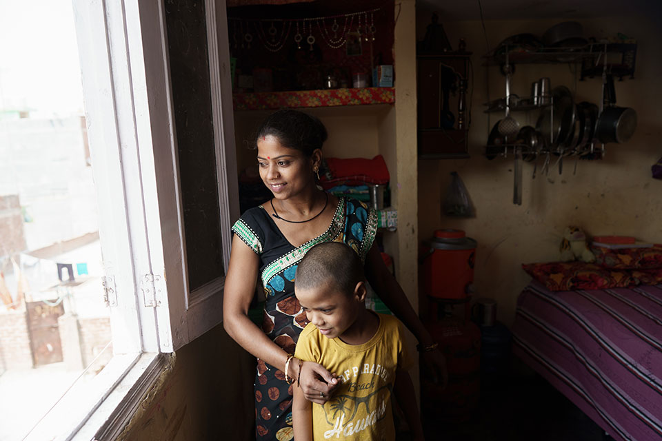 In this photo, Alpana Devi poses with her son, Monty, at her home in New Delhi. Photo: UN Women/Ruhani Kaur