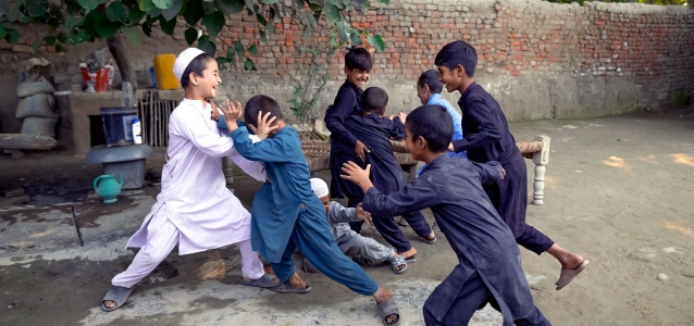 Children play outside Marjan’s quarters in a refugee village in Peshawar. Opportunities for socio-cultural activities to engage youth and children are limited but living in close quarters have allowed them to retain a sense of kinship. October 2022. Photo: UN Women Pakistan