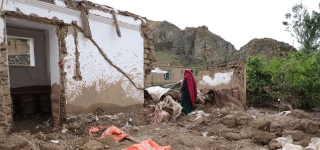A woman witnesses the destruction of her home after the floods that struck Ghor Province, Afghanistan, on 17 May.